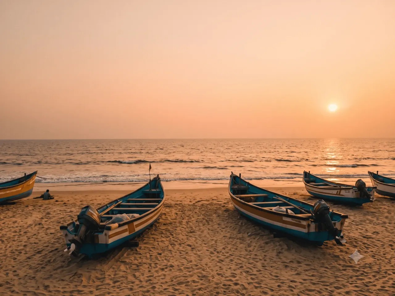 Panambur Beach coastline with fishing boats at sunset